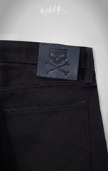 The back of the jeans featuring a signature black leather patch with an embossed skull and crossbones logo.