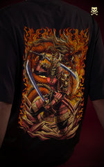 Close-up of the back of a black t-shirt featuring a detailed graphic of a skeletal samurai warrior wielding dual katanas. The character is framed by a coiled orange dragon and intense orange flames in a traditional Japanese art style.
