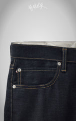 Detail of the front pocket and custom rivets on IRON CUT indigo jeans.