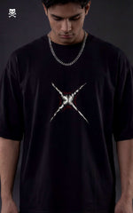 Person wearing a black t-shirt with a white graphic design on a dark background