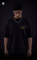 Person wearing a black t-shirt with a yellow broly ring on a black oversized t-shirt