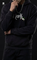 A man in a Mavrick Roronoa Zoro black anime hoodie with a white Gothic "MVRK" logo and a small Zoro-themed Jolly Roger skull graphic on the chest.