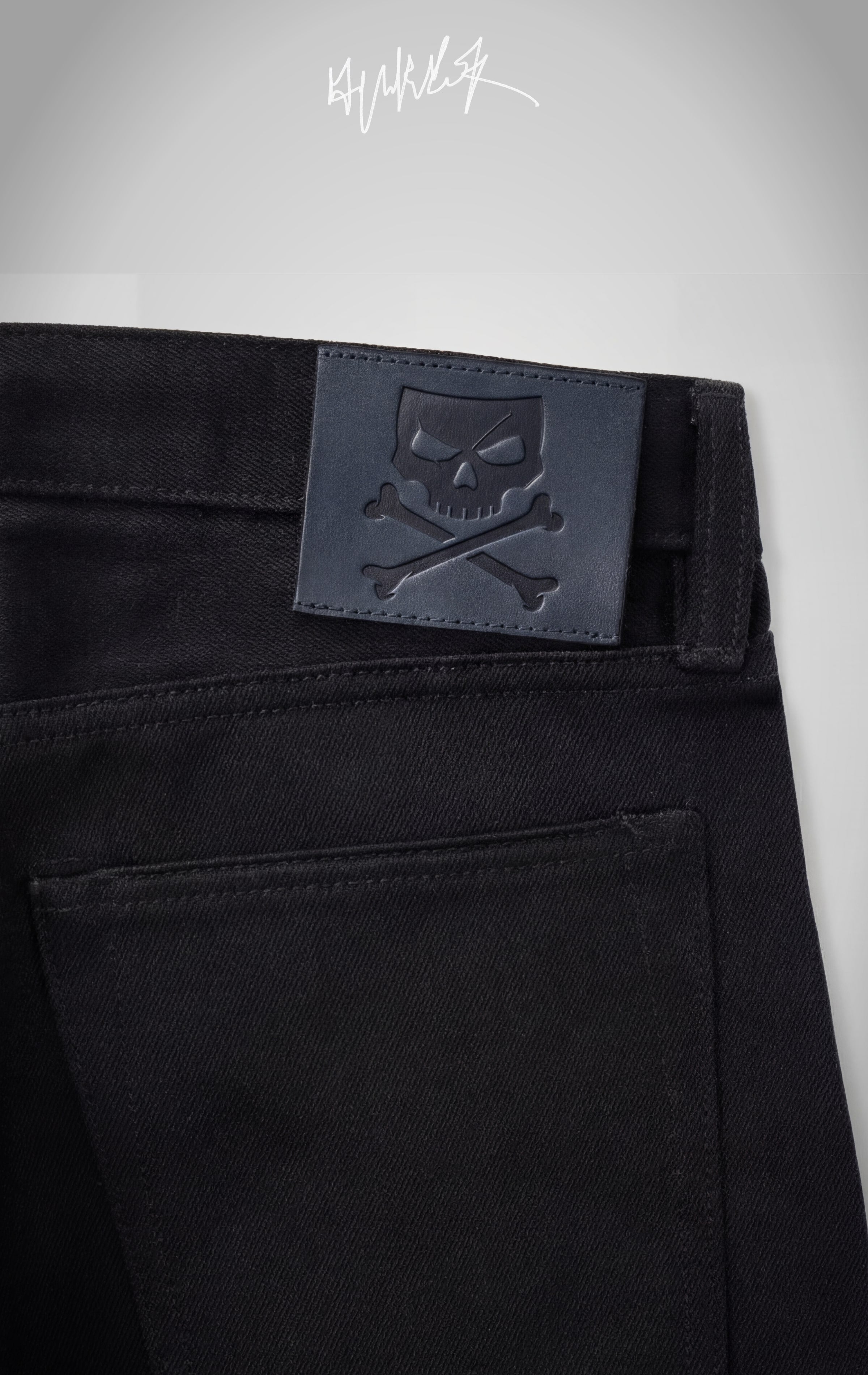 The back of the jeans featuring a signature black leather patch with an embossed skull and crossbones logo.