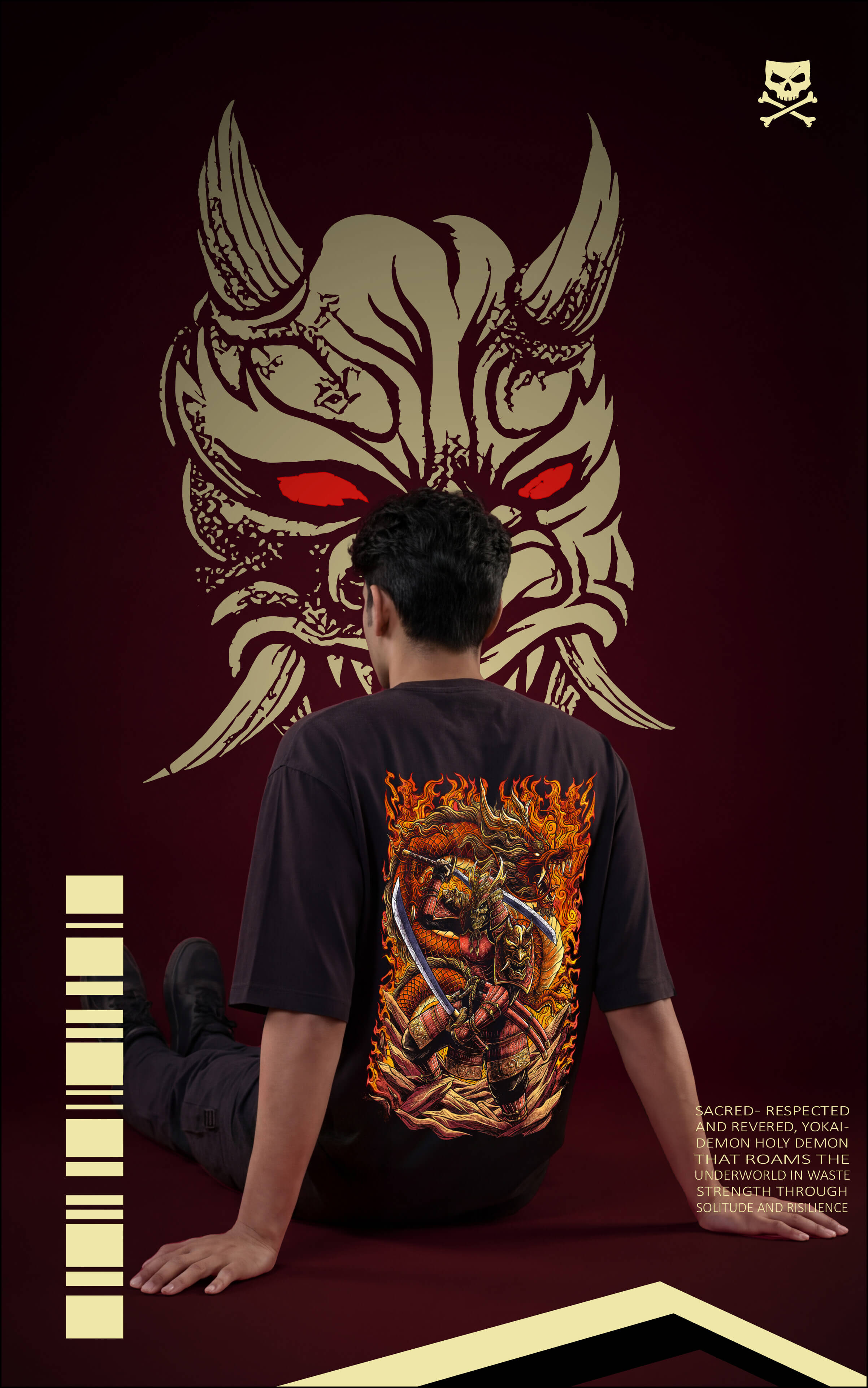 
Back view of a model sitting on the floor wearing a black graphic tee with a large, fiery samurai and dragon illustration. A giant stylized Hannya mask with glowing red eyes is superimposed in the background.