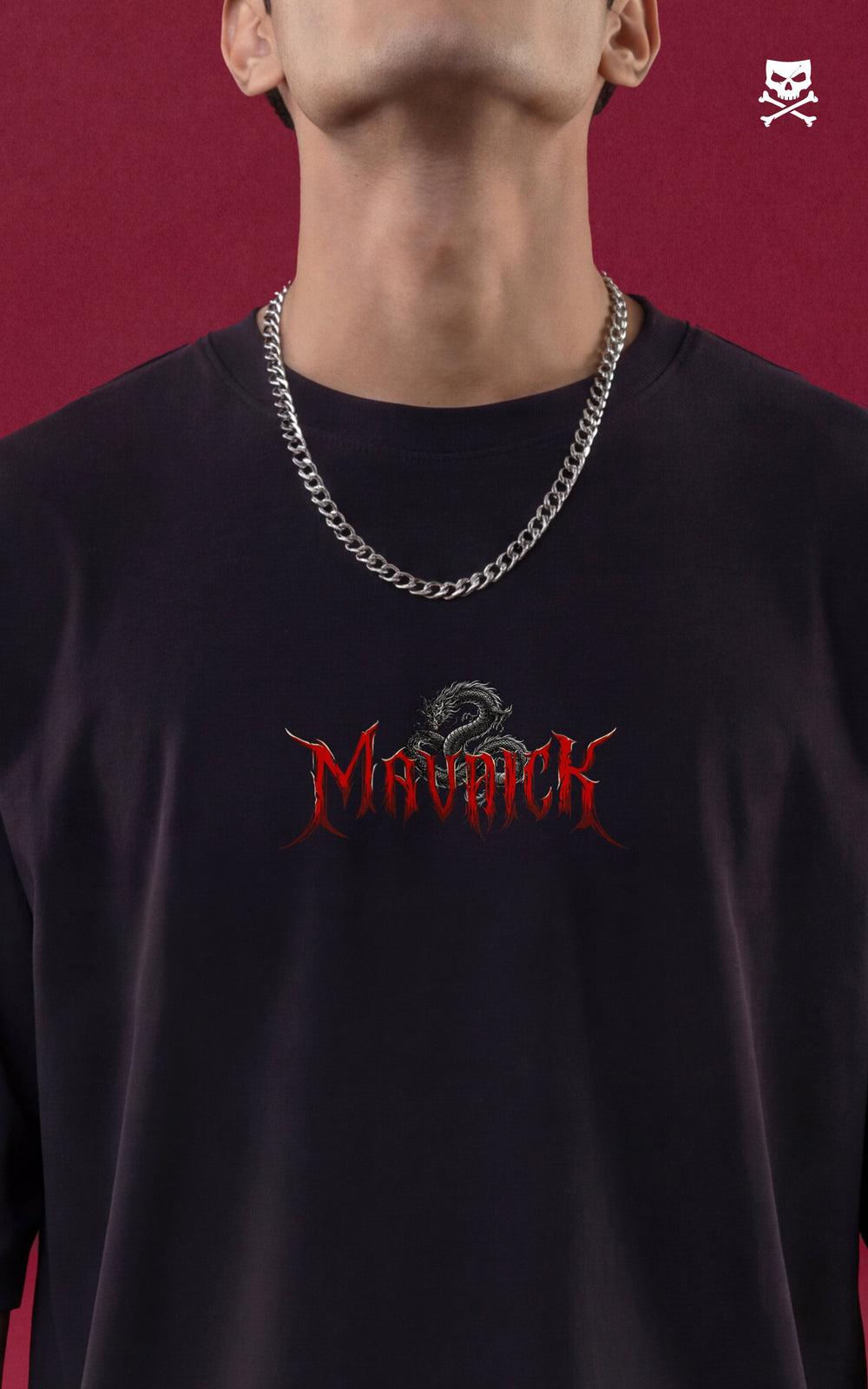 Close-up of a chest-level graphic on a black streetwear shirt featuring the word "MAVERICK" in a red, jagged metal font. A small, intricately detailed black and white dragon is perched on top of the typography, with a silver cuban link chain visible at the neck.
