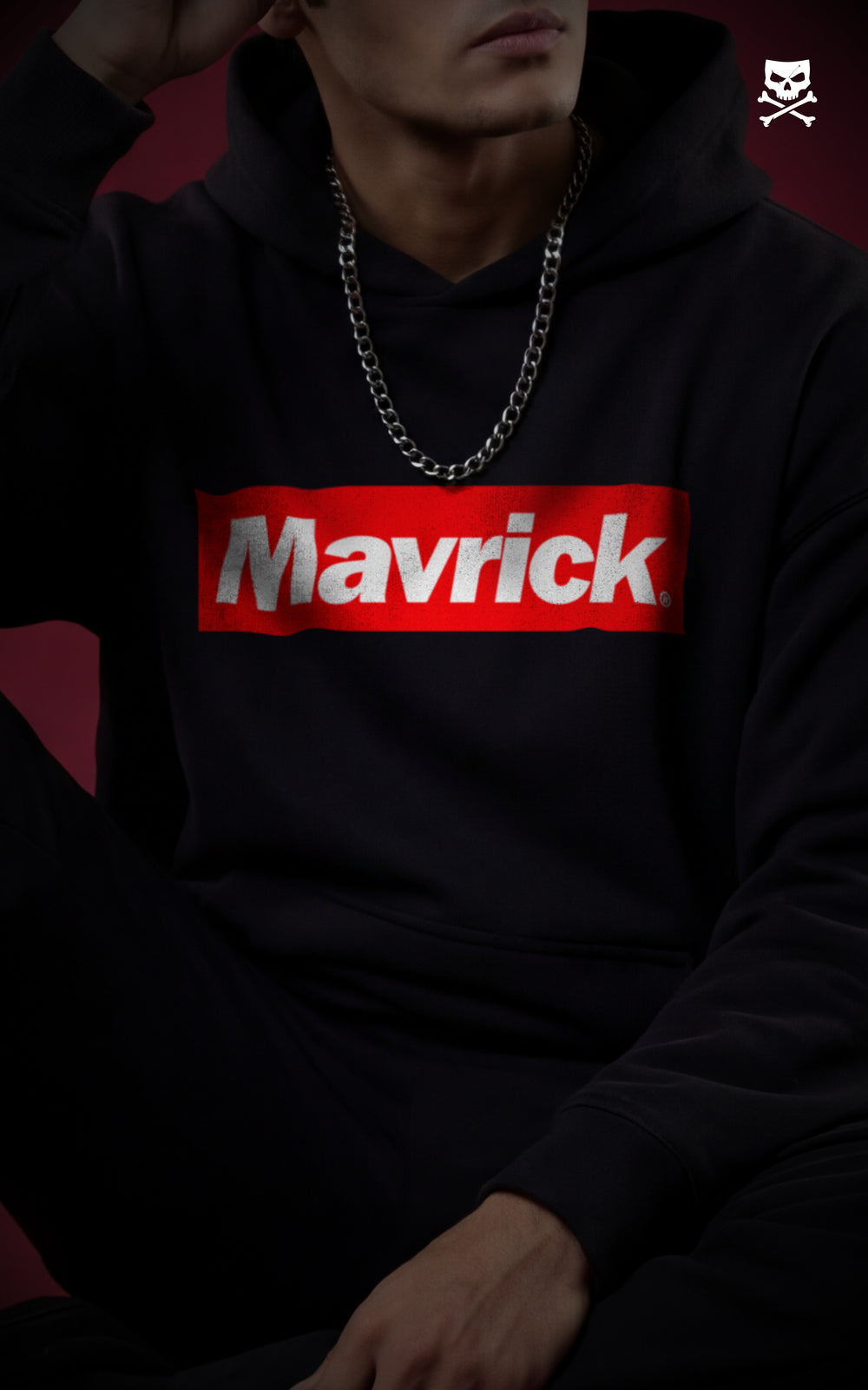 
Close-up view of the Mavrick red box logo on a black heavyweight hoodie, accessorized with a silver chain for a modern streetwear aesthetic.
