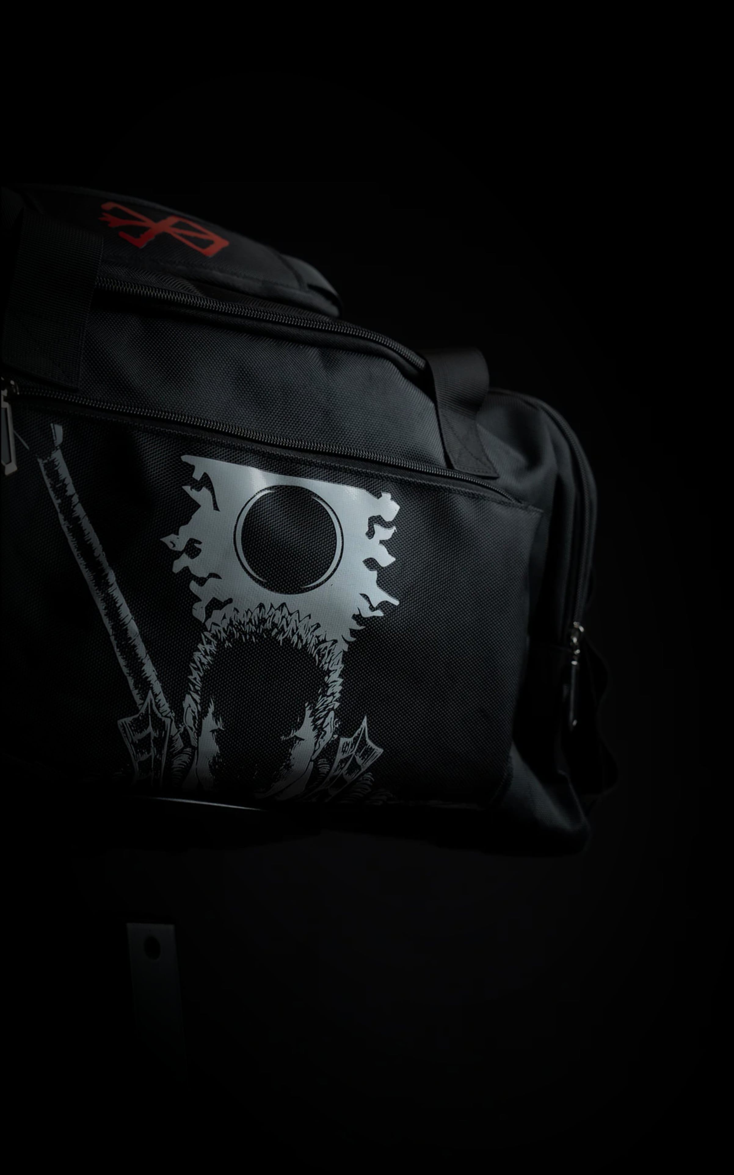 Side view of the Berserk travel bag showcasing the silver screen-printed graphic of Guts, the Eclipse, and the hilt of the Dragon Slayer sword.