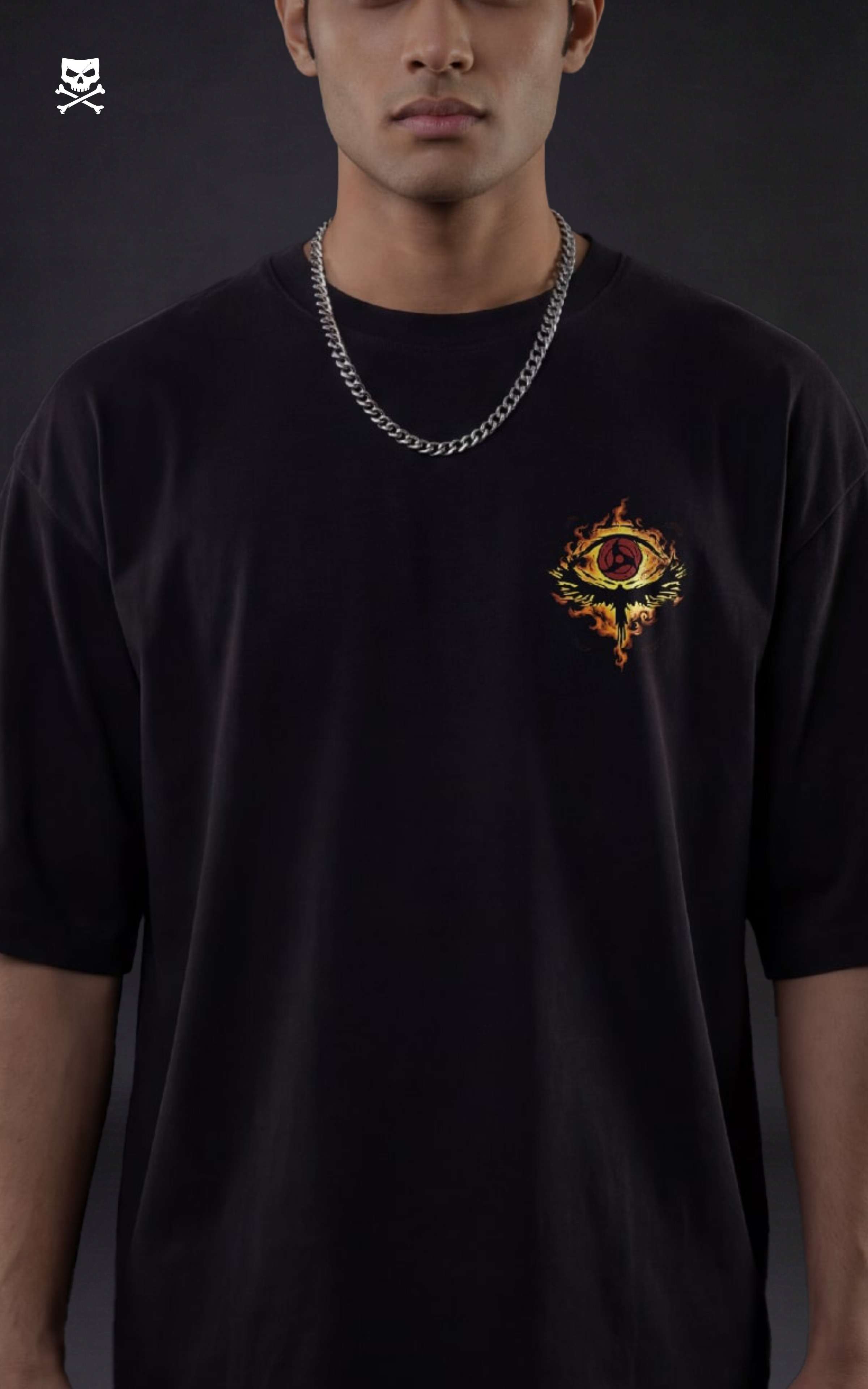 Person wearing a black t-shirt with tachi crow logo on front on a dark background