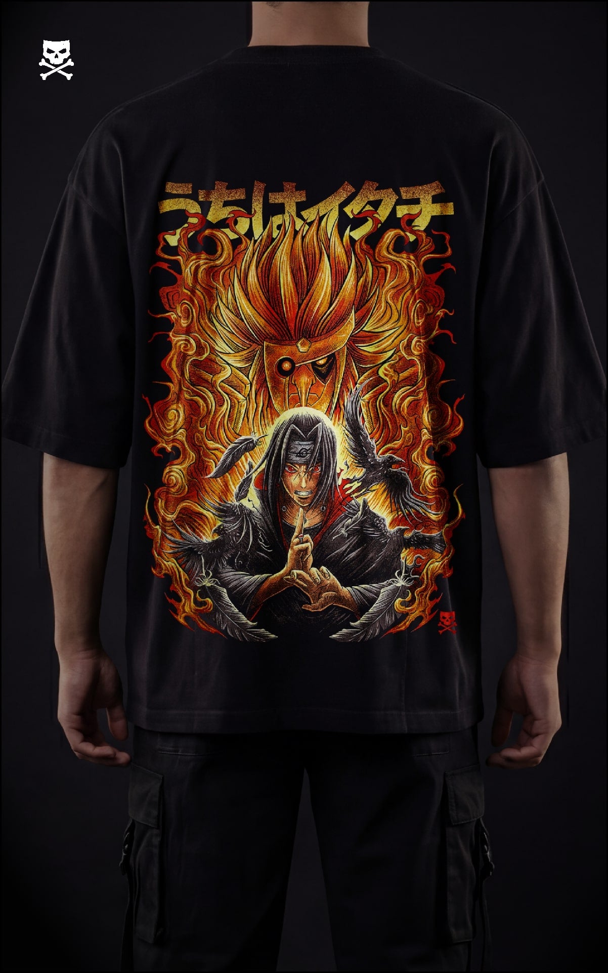 Closeup view of a model in a black heavyweight oversized t-shirt featuring Itachi Uchiha with a flaming orange Susanoo, black crows, and Japanese kanji streetwear design.