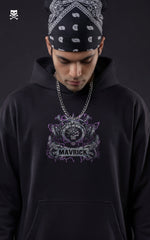 Front view of a model in a black Mavrick streetwear hoodie featuring a purple and silver Eustass Kid skull logo on the chest, styled with a black paisley bandana and silver chain.
