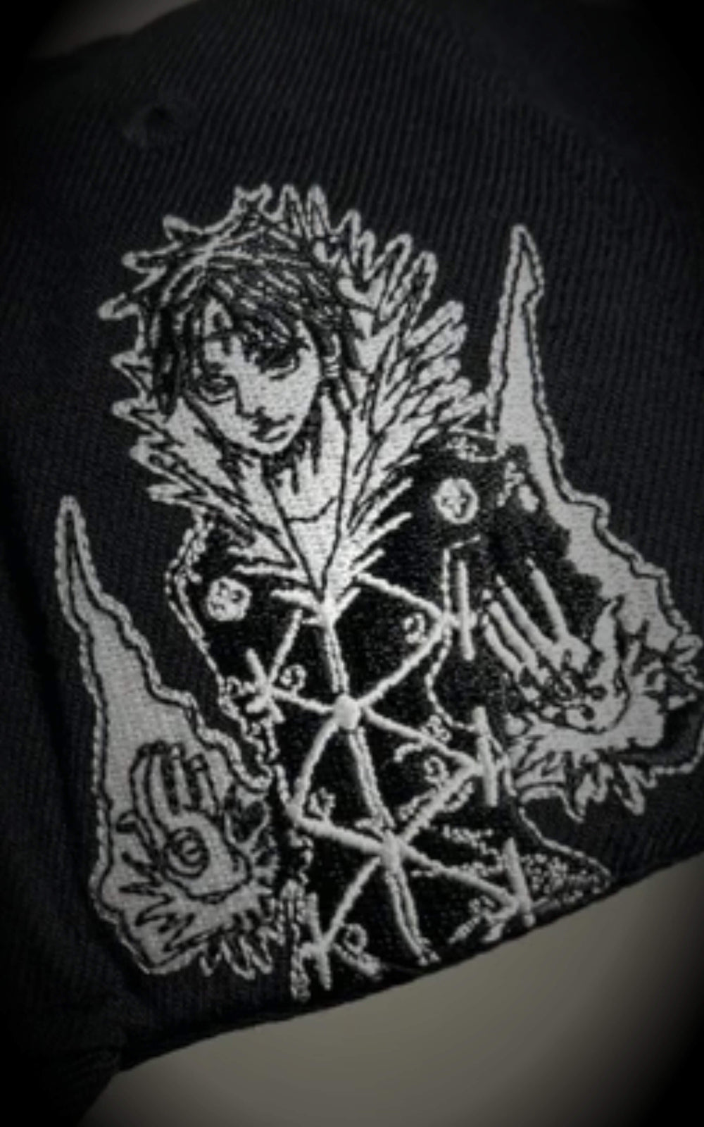 Macro shot of premium gothic embroidery on a black cap, detailing the "CH Los Angeles" text and a skeletal dragon-like motif.