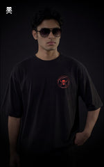 Person wearing a black t-shirt with a red logo on a dark background