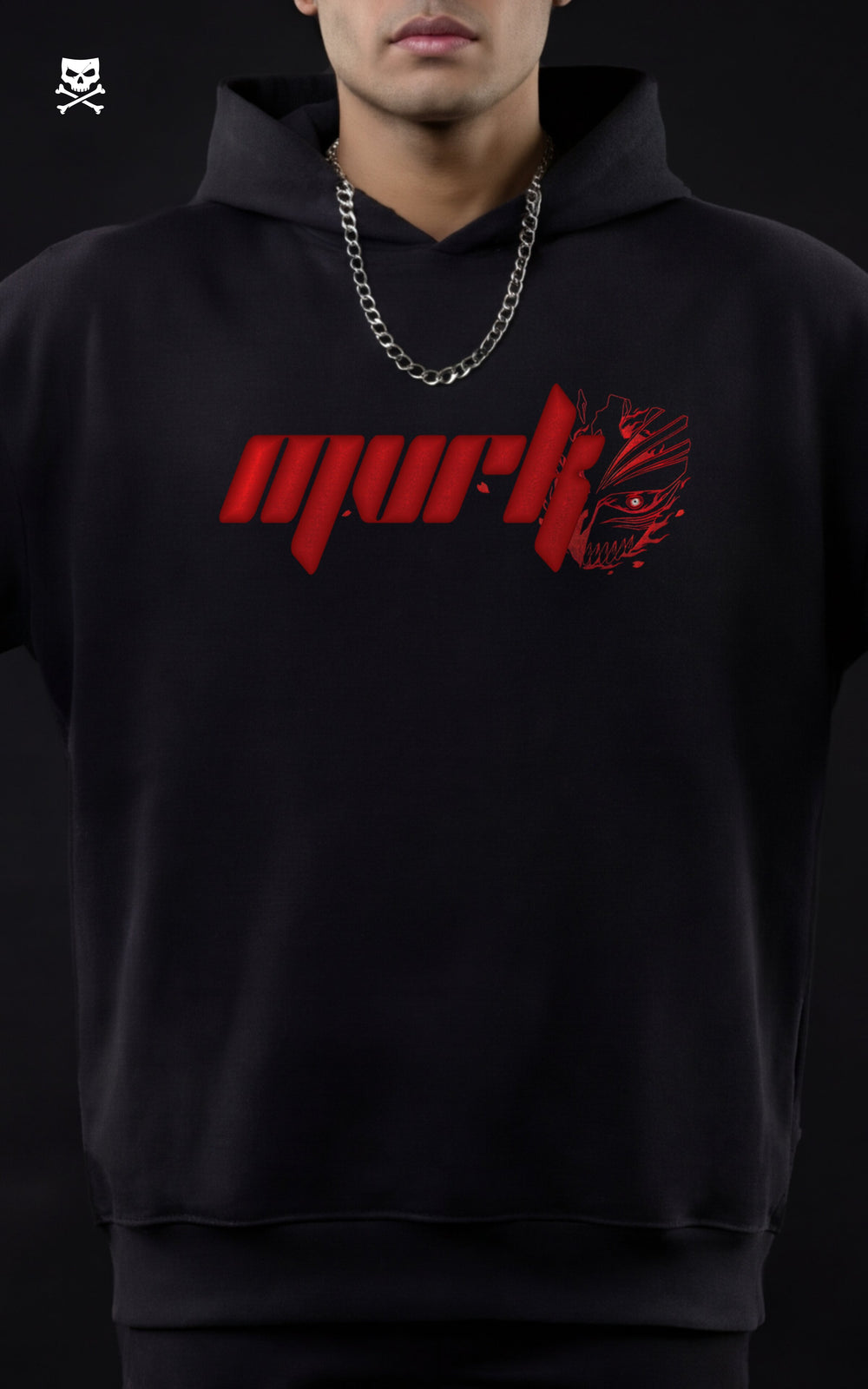 Front-facing portrait of a model in a black MVRK hoodie featuring a red chest logo stylized with half of Ichigo’s Hollow mask, paired with a silver chain.