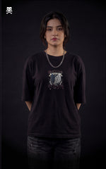 Person wearing a black t-shirt with a graphic design of scout regiment from attack on titan on a dark background