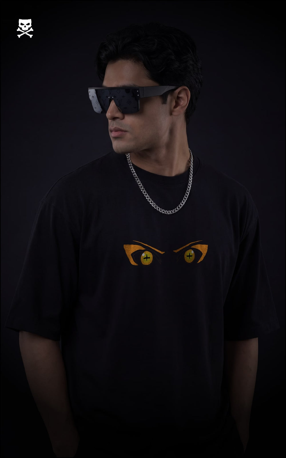 Person wearing a black t-shirt with  naruto sage eyes on front , standing against a dark background