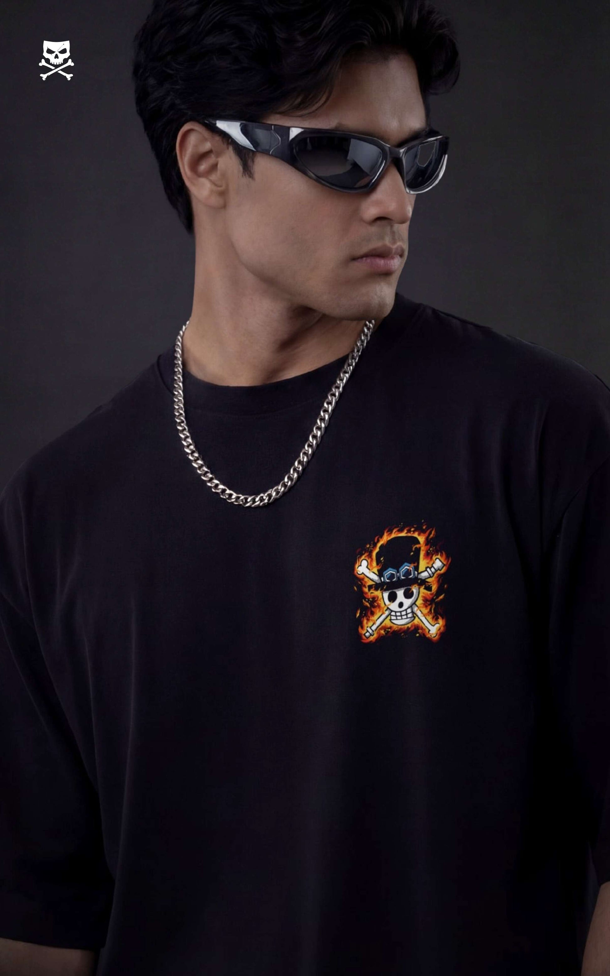 Person wearing a black t-shirt with a graphic design and sunglasses against a dark background