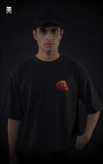 Person wearing a black t-shirt with a red punch from saitama on a dark background