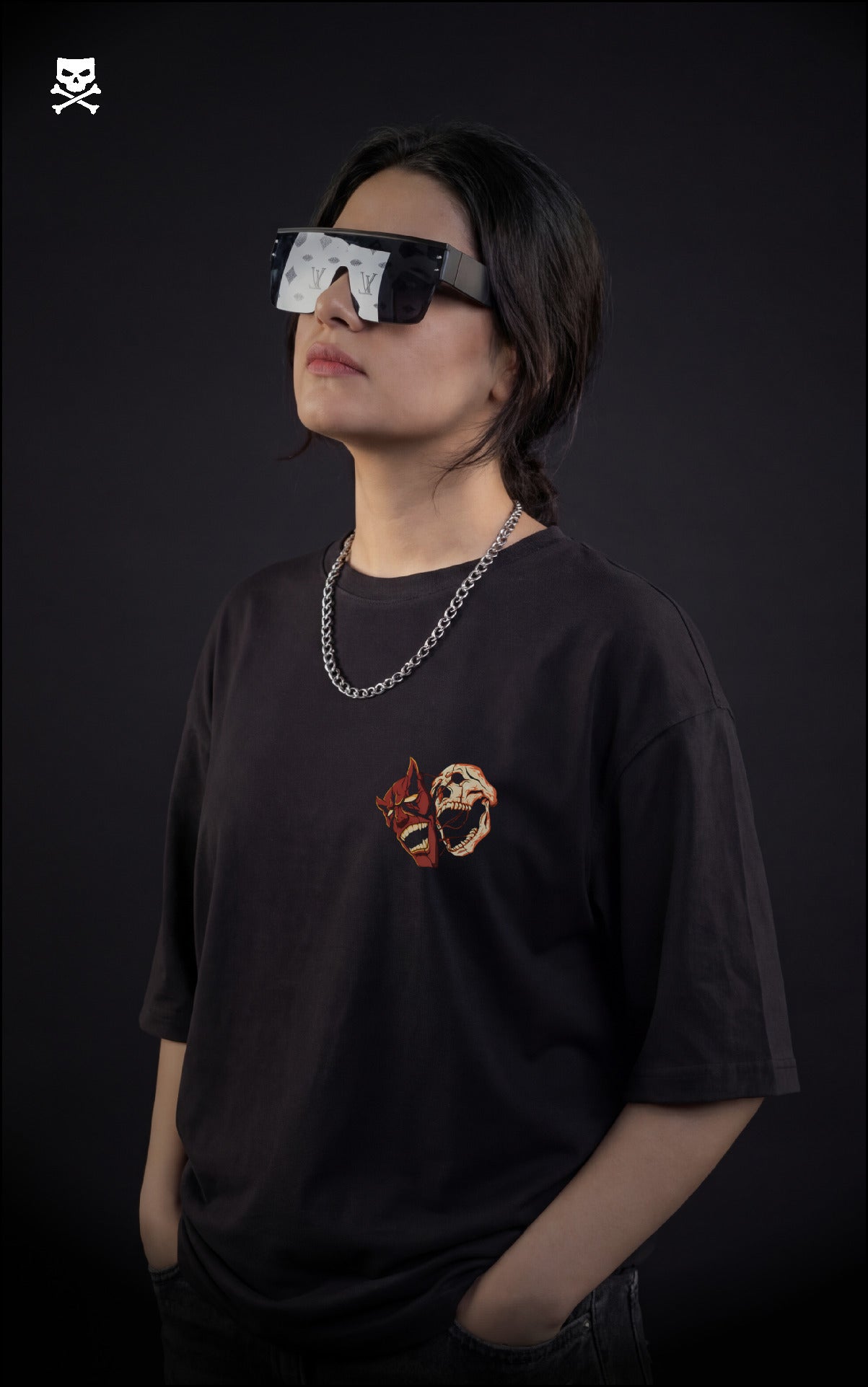Girl wearing a black t-shirt with a graphic design, standing against a dark background