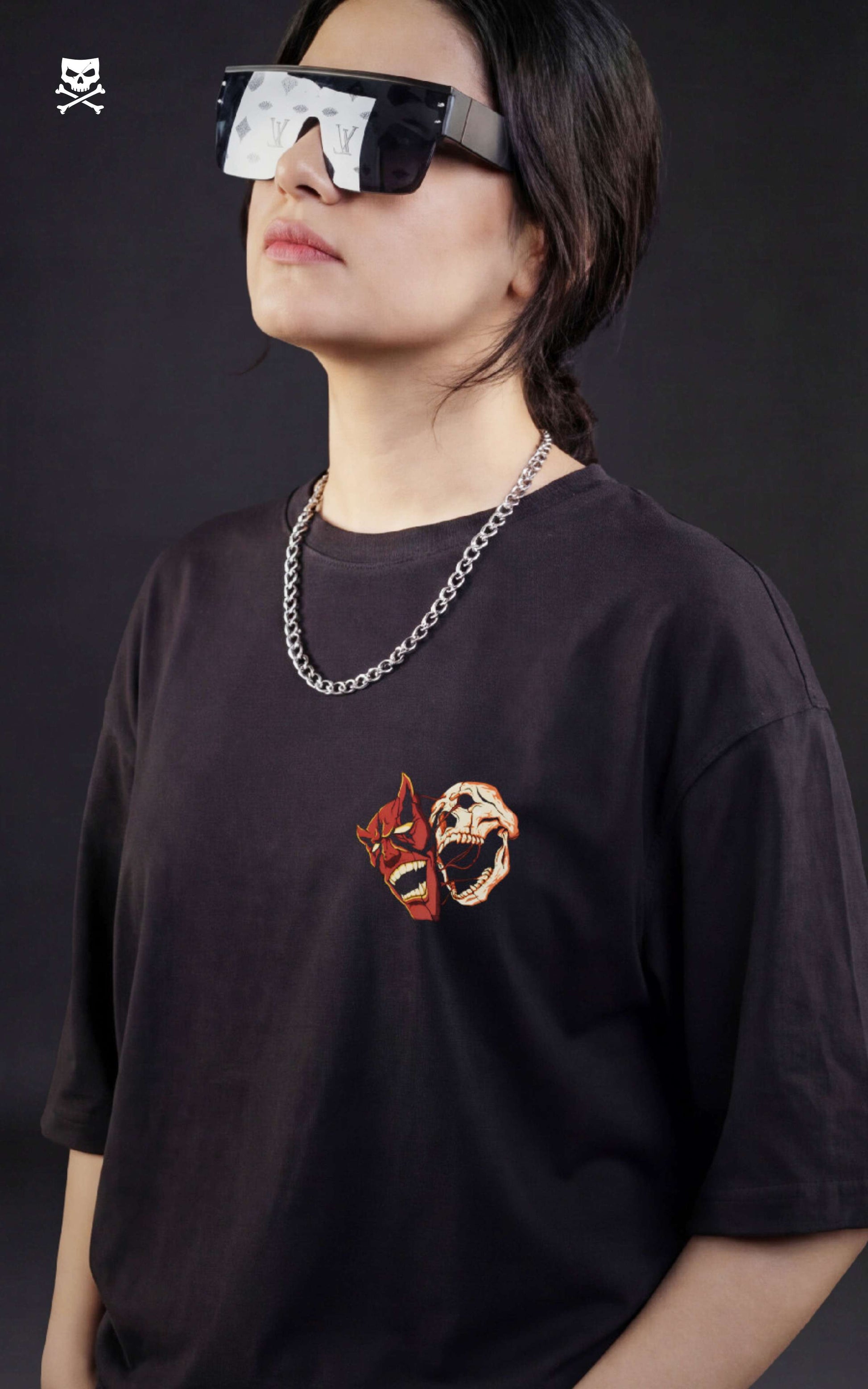 Girl wearing a black t-shirt with a graphic design, standing against a dark background